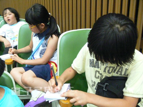 개회식날, 초등학교 어린이들이 의회 관람을 하면서 메모를 하고 있다.