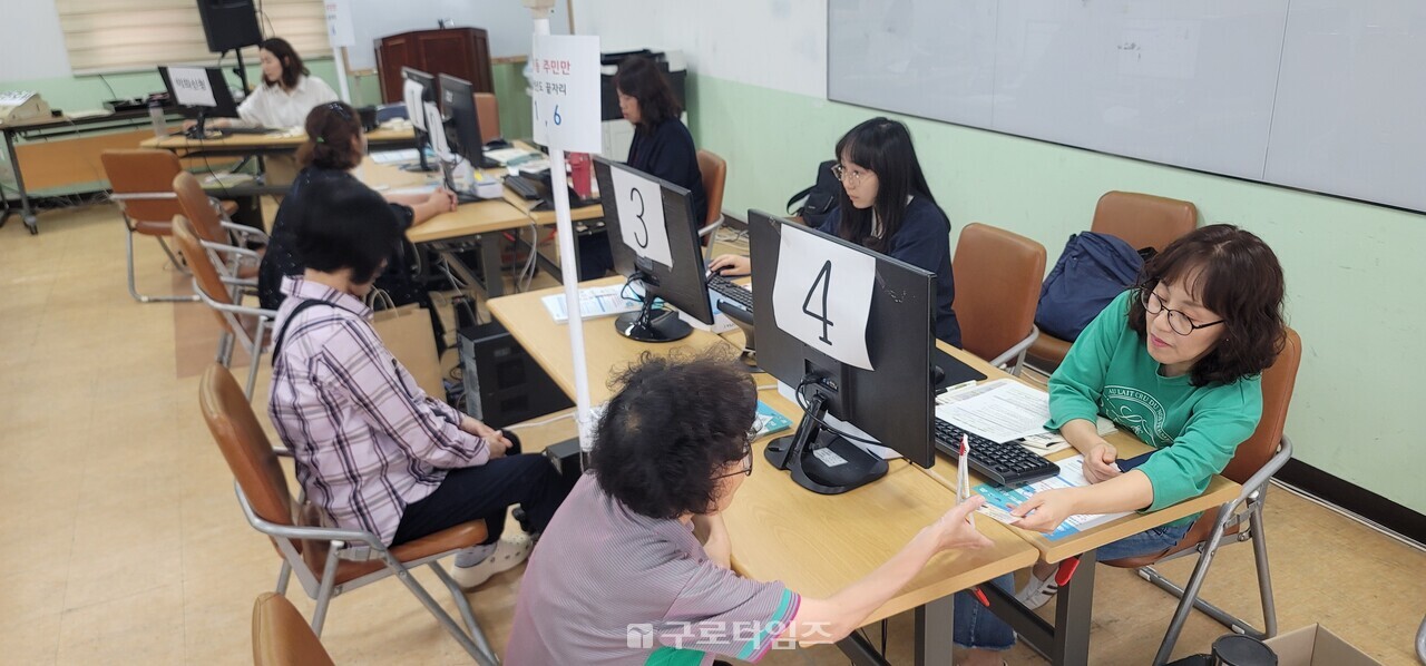민생회복소비쿠폰 2차 신청 첫날인 22일 오후 개봉1동주민센터 2층 신청현장. 한 주민이 10만원이 충전된 선불카드를 받고 있다.